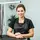 professional pet groomer portrait smiling in a clean modern salon environment